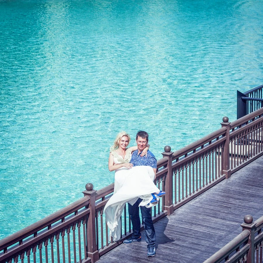 Man carrying woman on overwater bridge – Dreambox photo